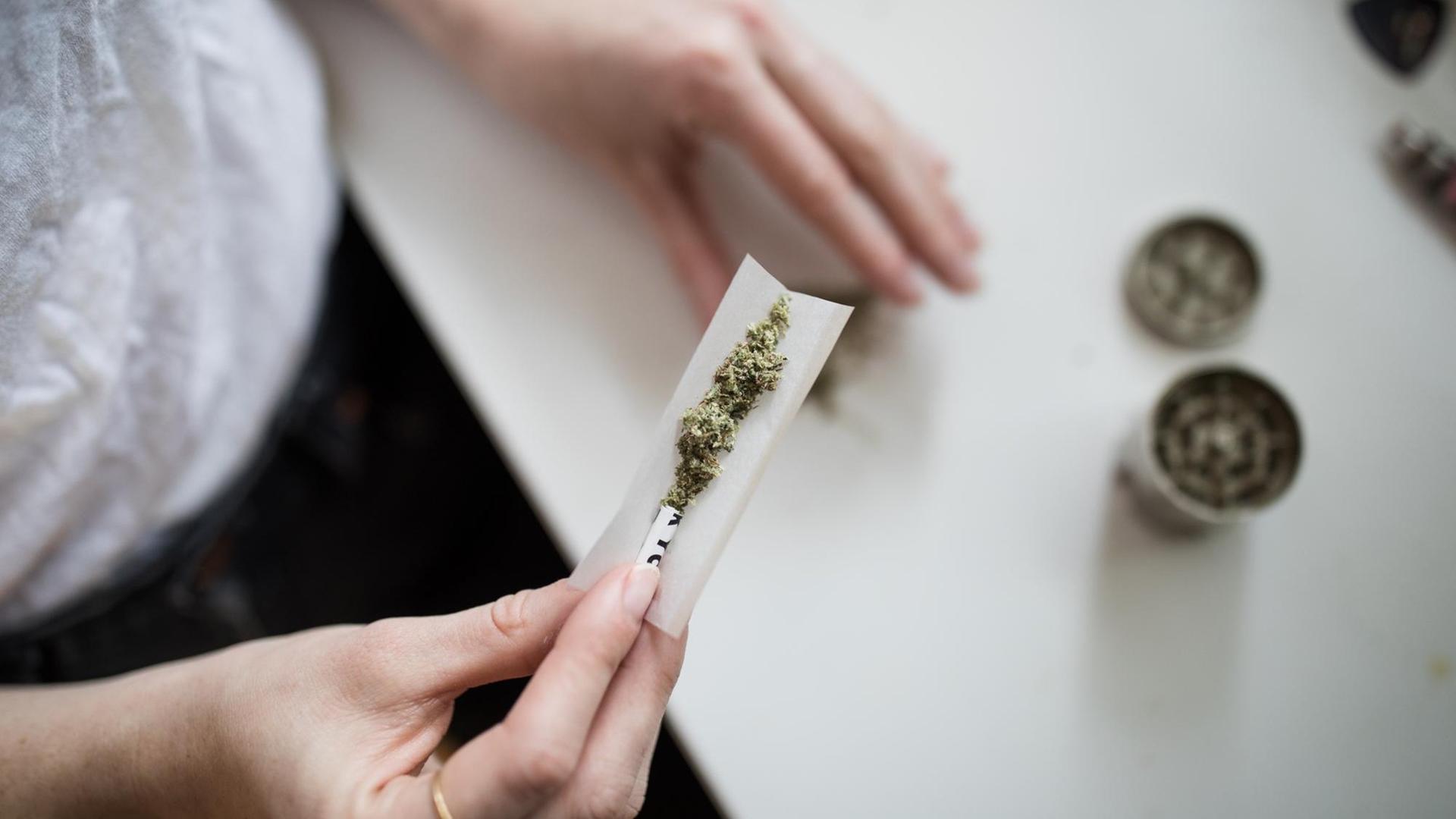 Draufsicht auf zwei Hände, die einen Joint drehen. Draufsicht auf zwei Hände, die einen Joint drehen.