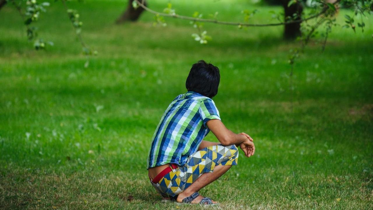 Ein afghanischer Flüchtling sitzt am 13.07.2016 im Garten eines Heims für unbegleitete, minderjährige Flüchtlinge in Döberkitz bei Bautzen (Sachsen). Ein afghanischer Flüchtling sitzt am 13.07.2016 im Garten eines Heims für unbegleitete, minderjährige Flüchtlinge in Döberkitz bei Bautzen (Sachsen).