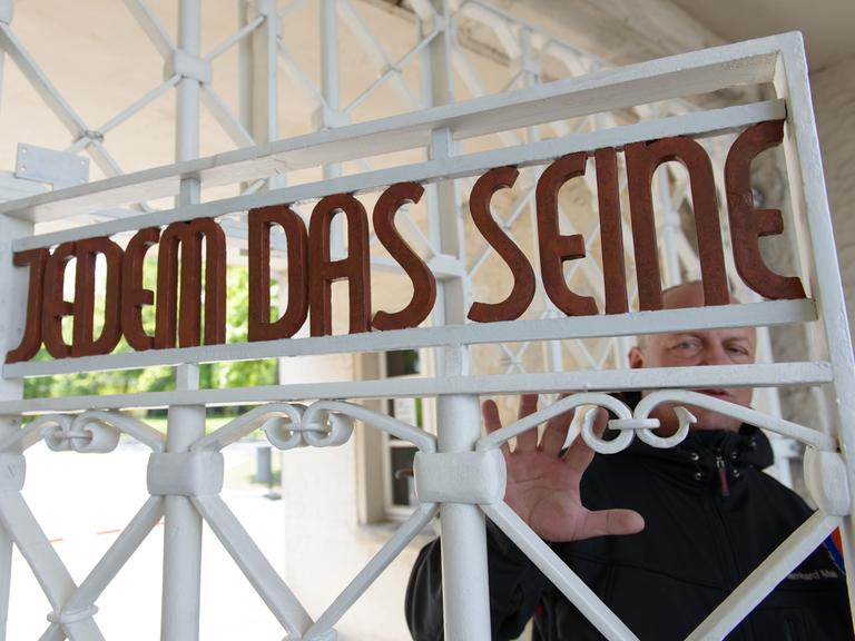 Restaurator Bernhard Mai steht in der Gedenkstätte Buchenwald am restaurierten und nach Befunden in den originalen Farben gestrichene Lagertor des ehemaligen Konzentrationslagers mit der Inschrift "Jedem das Seine".