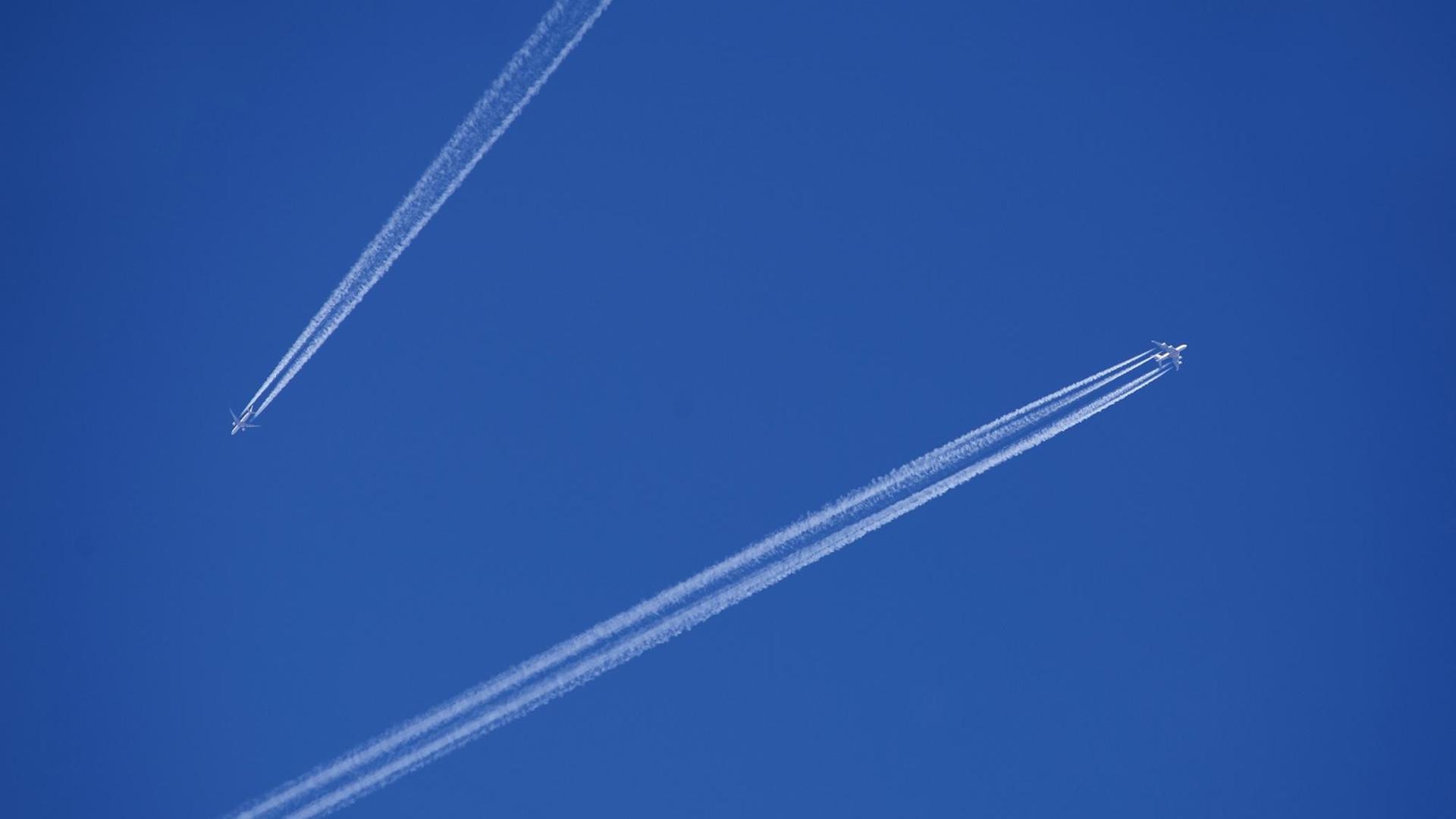 Zwei Flugzeuge mit Kondensstreifen am blauen Himmel. Zwei Flugzeuge mit Kondensstreifen am blauen Himmel.