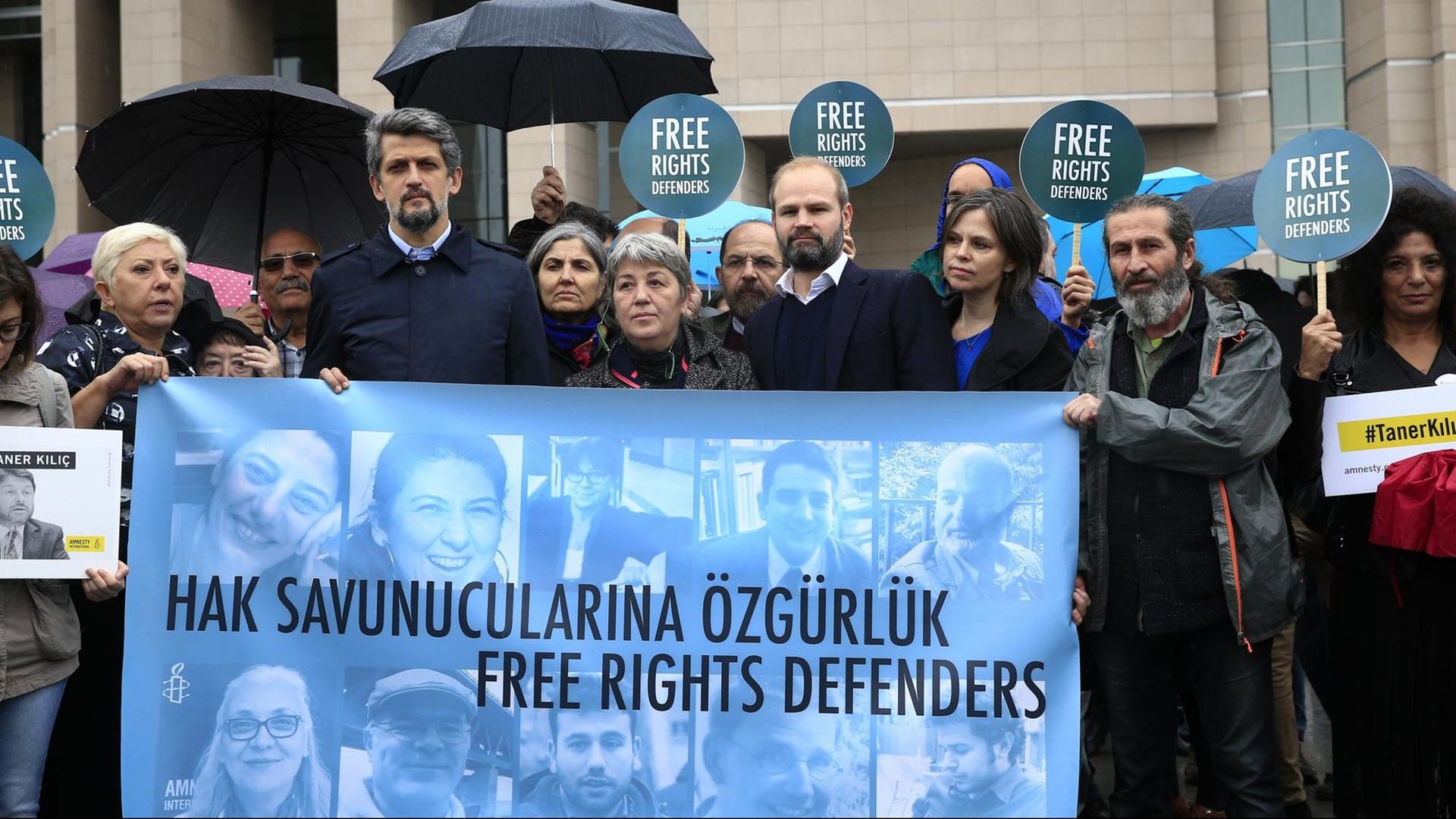 Menschenrechts-Aktivisten demonstrieren am 25.10.2017 vor einem Gericht in Istanbul (Türkei) mit einem Transparent mit Bildern der Angeklagten gegen den Prozess gegen elf Menschenrechtler, darunter auch der Deutsche Peter Steudtner (auf dem Banner der 2.v.r. unten). Menschenrechts-Aktivisten demonstrieren am 25.10.2017 vor einem Gericht in Istanbul (Türkei) mit einem Transparent mit Bildern der Angeklagten gegen den Prozess gegen elf Menschenrechtler, darunter auch der Deutsche Peter Steudtner (auf dem Banner der 2.v.r. unten).