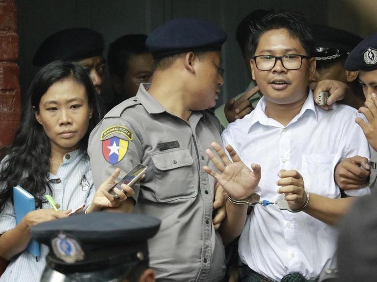 Der Reuters-Journalist Wa Lone stellt sich den Fragen von Medienvertretern, bevor er in ein Polizeifahrzeug steigt.