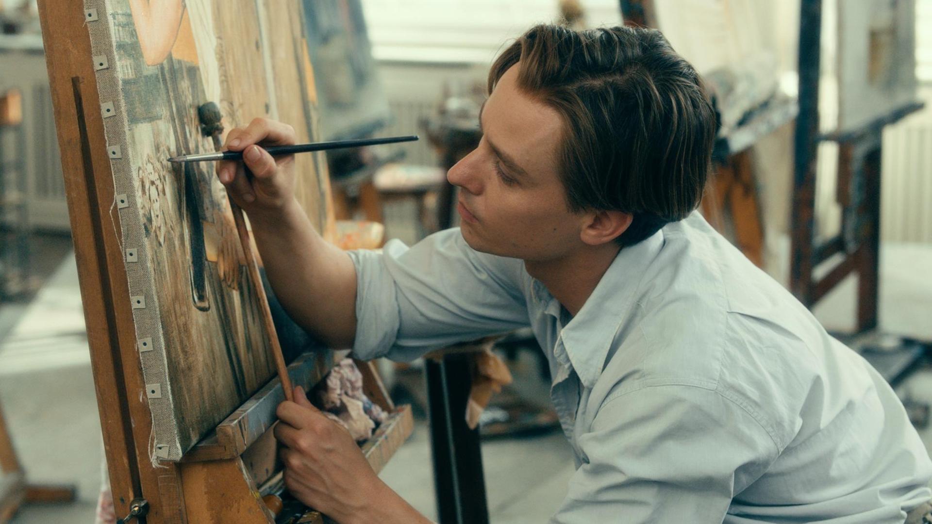 Tom Schilling vor einer Leinwand mit einem Pinsel in der Hand. Szene aus dem Film "Werk ohne Autor". Tom Schilling vor einer Leinwand mit einem Pinsel in der Hand. Szene aus dem Film "Werk ohne Autor".