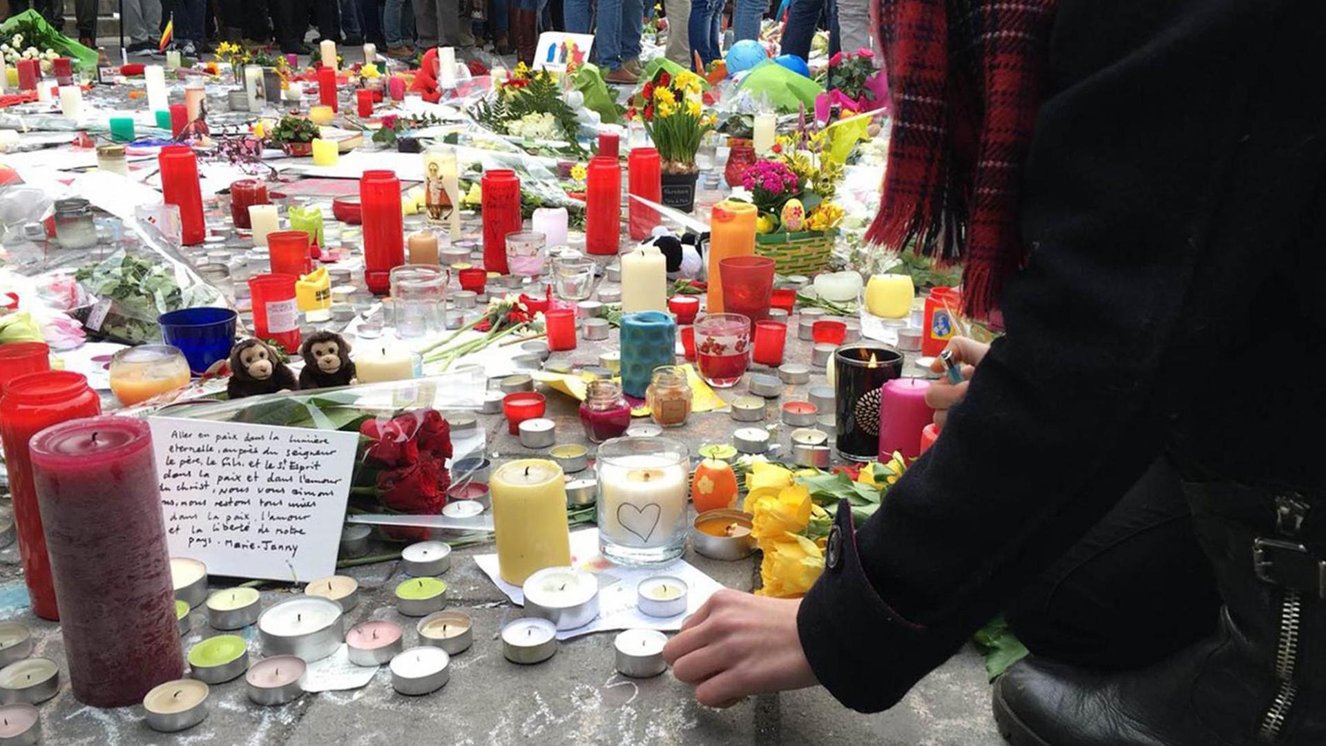 Teilnehmer einer Schweigeminute in Brüssel legen am Karfreitag nach den Terroranschlägen Blumen und Kerzen nieder Teilnehmer einer Schweigeminute in Brüssel legen am Karfreitag nach den Terroranschlägen Blumen und Kerzen nieder