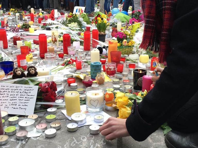Teilnehmer einer Schweigeminute in Brüssel legen am Karfreitag nach den Terroranschlägen Blumen und Kerzen nieder