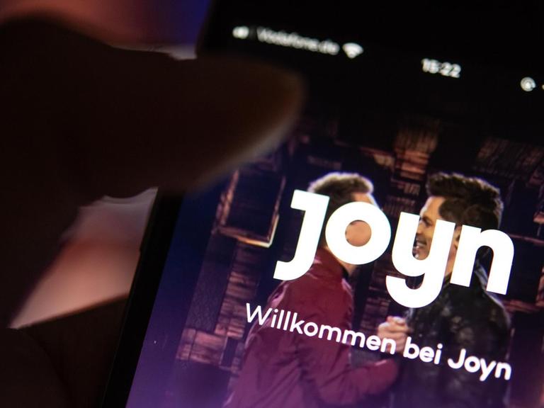Auf dem Bildschirm eines Smartphones wird die App der Streaming-Plattform Joyn angezeigt. Mit der neuen Plattform sollen die Angebote von 55 TV-Sendern in einer App nutzbar seien.