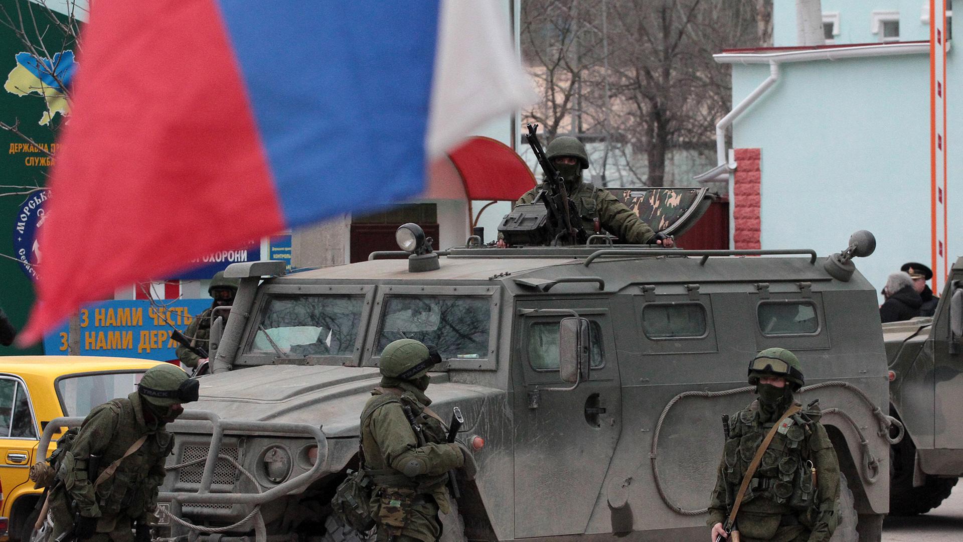 Soldaten der Ukraine haben Stellung bezogen vor einem Panzer und der Fahne des Landes in Balaklava auf der Krim. Soldaten der Ukraine haben Stellung bezogen vor einem Panzer und der Fahne des Landes in Balaklava auf der Krim.