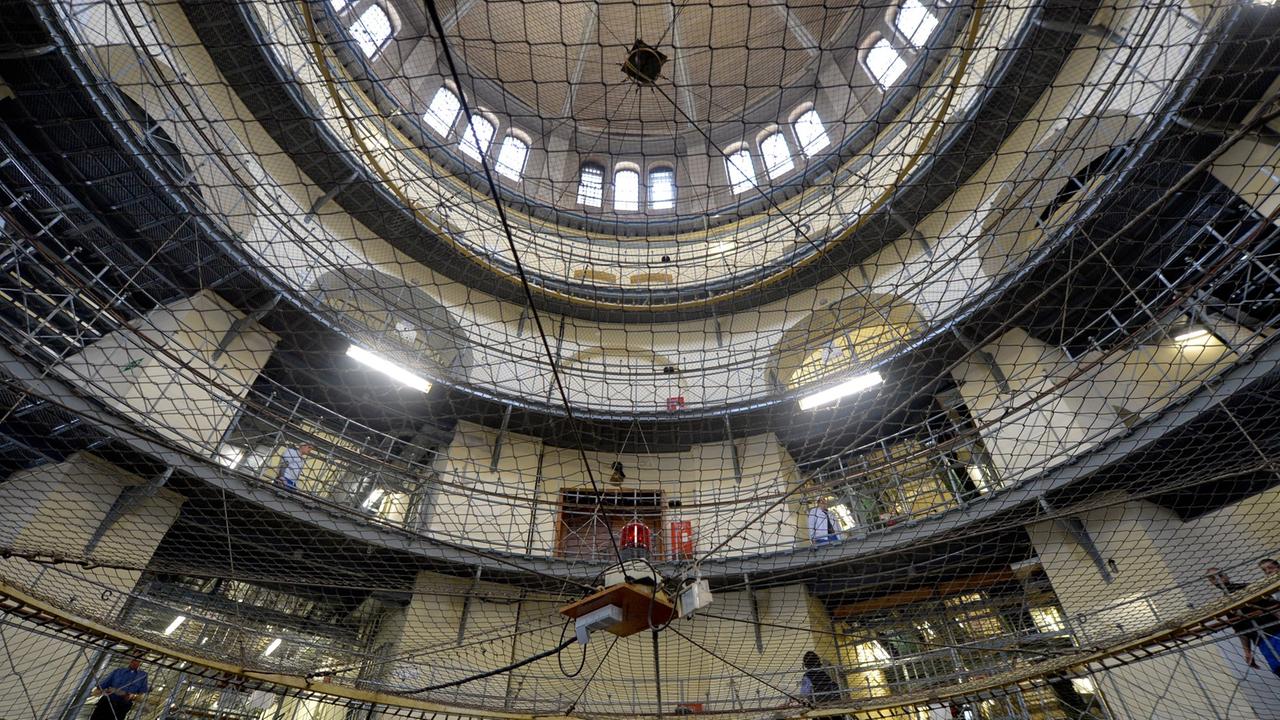 Häftlinge und Justizvollzugsbeamte stehen am 23.01.2014 in Berlin im Mittelbau der Justizvollzugsanstalt Moabit.
