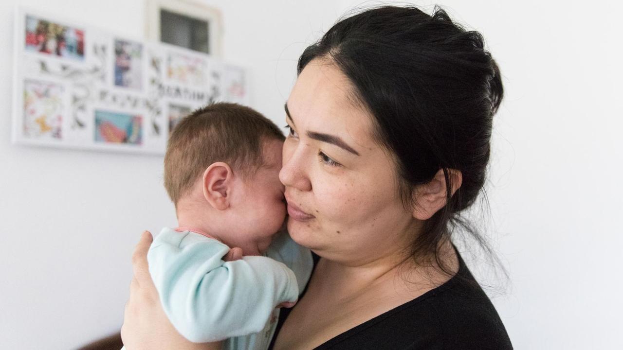 Junge Frau mit Baby auf dem Arm Junge Frau mit Baby auf dem Arm