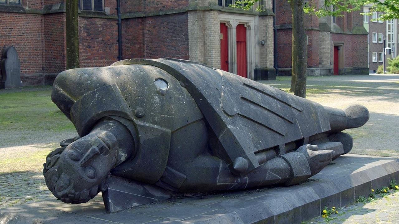Das Denkmal "Toter Krieger" von Ewald Matare vor der Stifts-und Prosteikirche St. Mariä Himmelfahrt in der nordrhein-westfälischen Stadt Kleve am 09.05.2005. Das Denkmal wurde im Jahre 1934 als Teil eines Ehrenmals für die Gefallenen des Ersten Weltkrieges aufgestellt. 1938, nur vier Jahre später, wurde es von den Nationalsozialisten zerstört. Das Denkmal wurde restauriert und 1981 wieder aufgestellt als Mahnmal gegen Unrecht und Gewalt. Das Denkmal "Toter Krieger" von Ewald Matare vor der Stifts-und Prosteikirche St. Mariä Himmelfahrt in der nordrhein-westfälischen Stadt Kleve am 09.05.2005. Das Denkmal wurde im Jahre 1934 als Teil eines Ehrenmals für die Gefallenen des Ersten Weltkrieges aufgestellt. 1938, nur vier Jahre später, wurde es von den Nationalsozialisten zerstört. Das Denkmal wurde restauriert und 1981 wieder aufgestellt als Mahnmal gegen Unrecht und Gewalt.