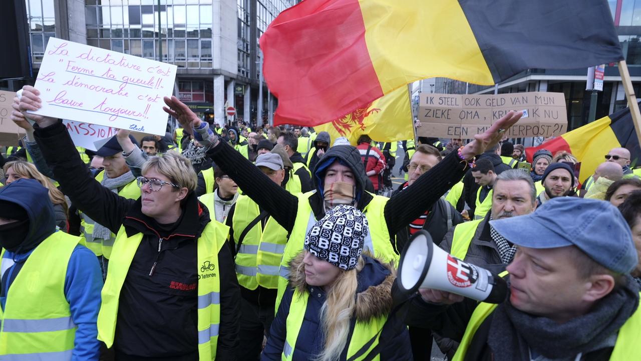 In Brüssel protestieren Menschen in gelben Warnwesten gegen die Regierungspolitik. In Brüssel protestieren Menschen in gelben Warnwesten gegen die Regierungspolitik.