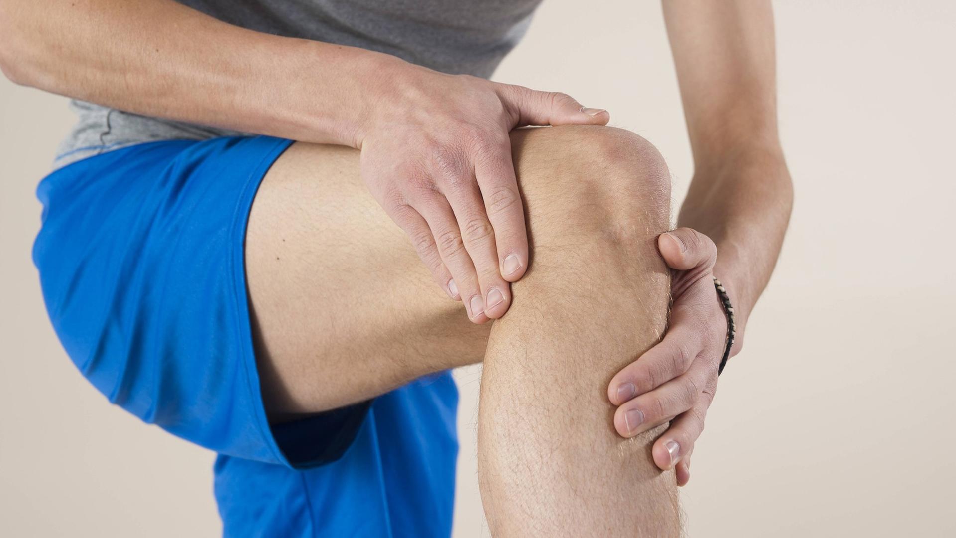 Ein Mann hält sein Knie. Ein Mann hält sein Knie.