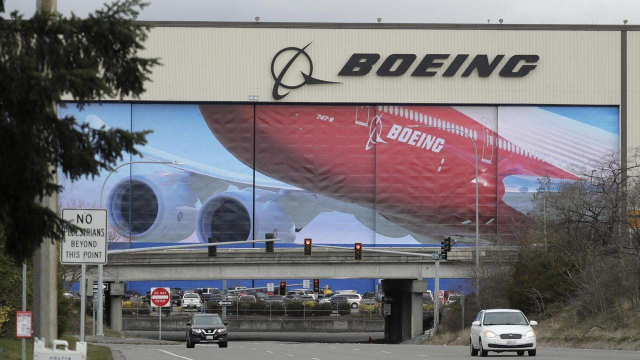 Autos fahren an der Boeing-Produktionsstätte vorbei. Autos fahren an der Boeing-Produktionsstätte vorbei.