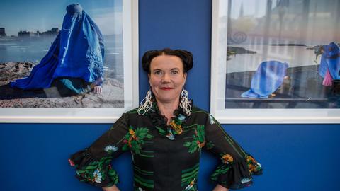 Die finnische Autorin Rosa Liksom steht am 05.10.2014 in Frankfurt am Main (Hessen) vor Bildern ihrer Fotoausstellung "Burka", für die sie Frauen mit blauen afghanischen Burkas in finnischen Landschaften fotografiert hat. Mit ihrem aktuellen Roman "Abteil Nr.6" ist die vielseitige Künstlerin auch auf der diesjährigen Buchmesse vetreten.