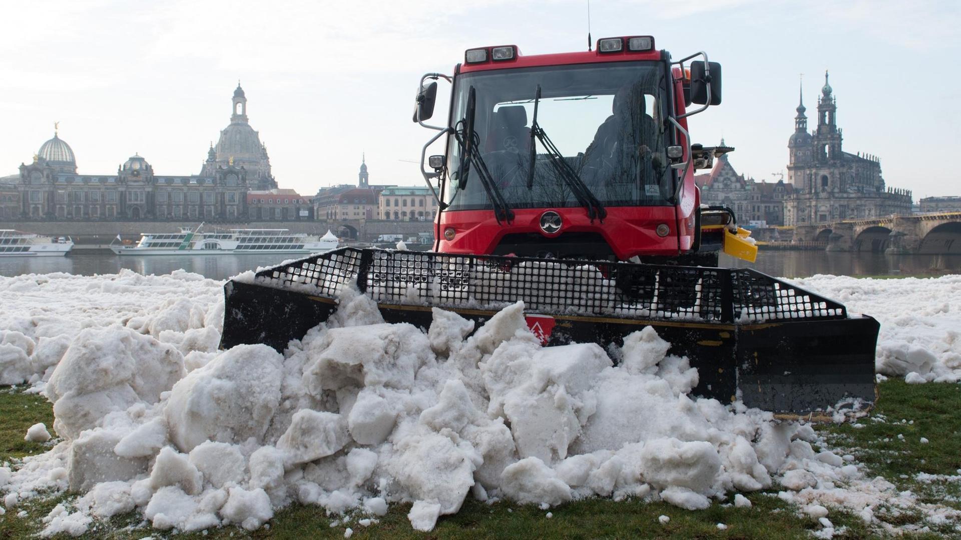 Ein Pistenbully präpariert am Elbufer in Dresden eine Wettkampfstrecke mit künstlichem Schnee. Ein Pistenbully präpariert am Elbufer in Dresden eine Wettkampfstrecke mit künstlichem Schnee.