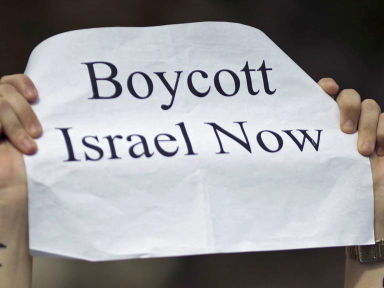 "Boycott Israel Now" steht am 09.08.2014 in Berlin bei einer Demonstration gegen den Krieg in Gaza auf dem Papier einer Frau, welche Free gaza auf den Armen stehen hat. Mehrere hundert Menschen, darunter Palästinenser und Menschen Jüdischer Herkunft haben gemeinsam in einer Demo vom Axel Springer Gebäude zum Potsdamer Platz gegen den Konflikt in Gaza demonstriert.