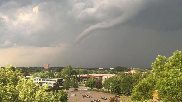 Das Foto zeigt die schrägliegende Windhose, die aus dem Himmel über einem Parkplatz herausragt Das Foto zeigt die schrägliegende Windhose, die aus dem Himmel über einem Parkplatz herausragt