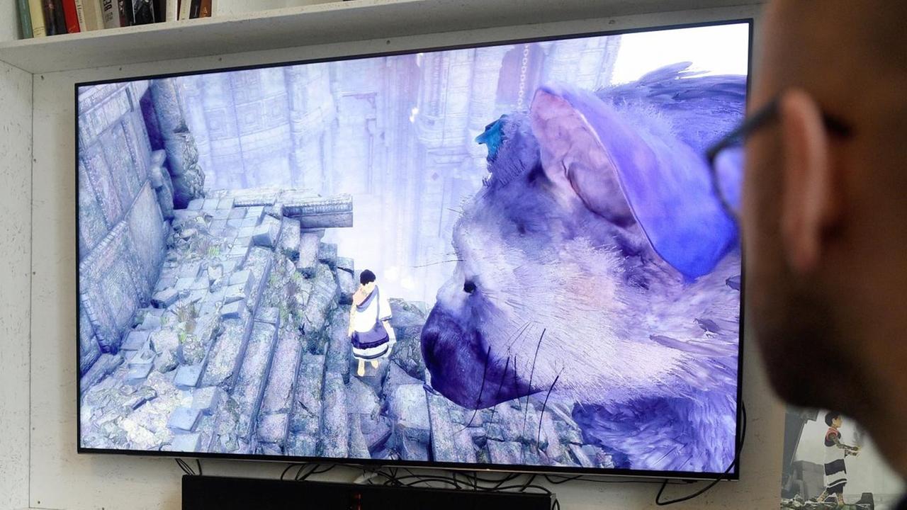 Ein Mann spielt das Game "The Last Guardian" bei einem PS4 Pro-Premieren-Event in Berlin. Zu sehen sind die zwei Protagonisten des Spiels: Der kleine Junge und die Kreatur Trico, eine Kreuzung aus Maus und Vogel.