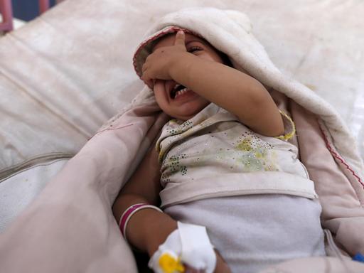 Ein Mädchen liegt im Jemen in einem Krankenhausbett und weint.