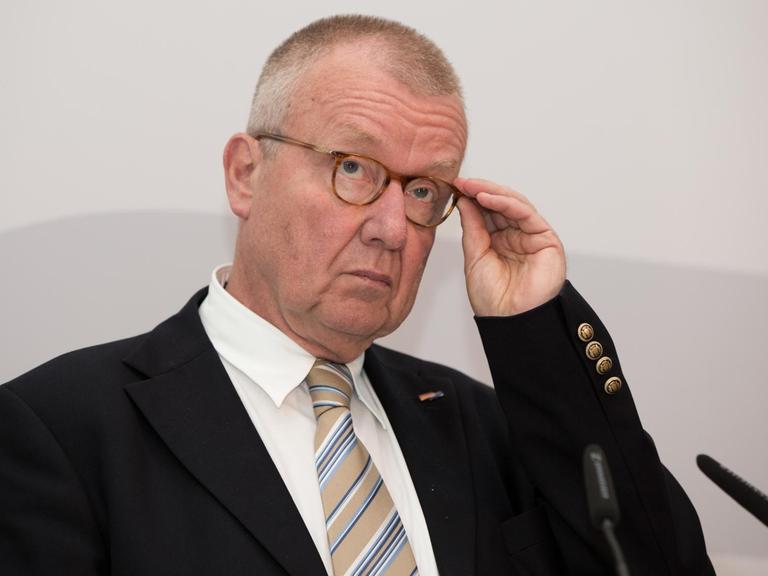 Das Bild zeigt Ruprecht Polenz, Präsident Deutsche Gesellschaft für Osteuropakunde. Er fasst sich vor grauem Hintergrund mit der linken Hand an seine Brille.
