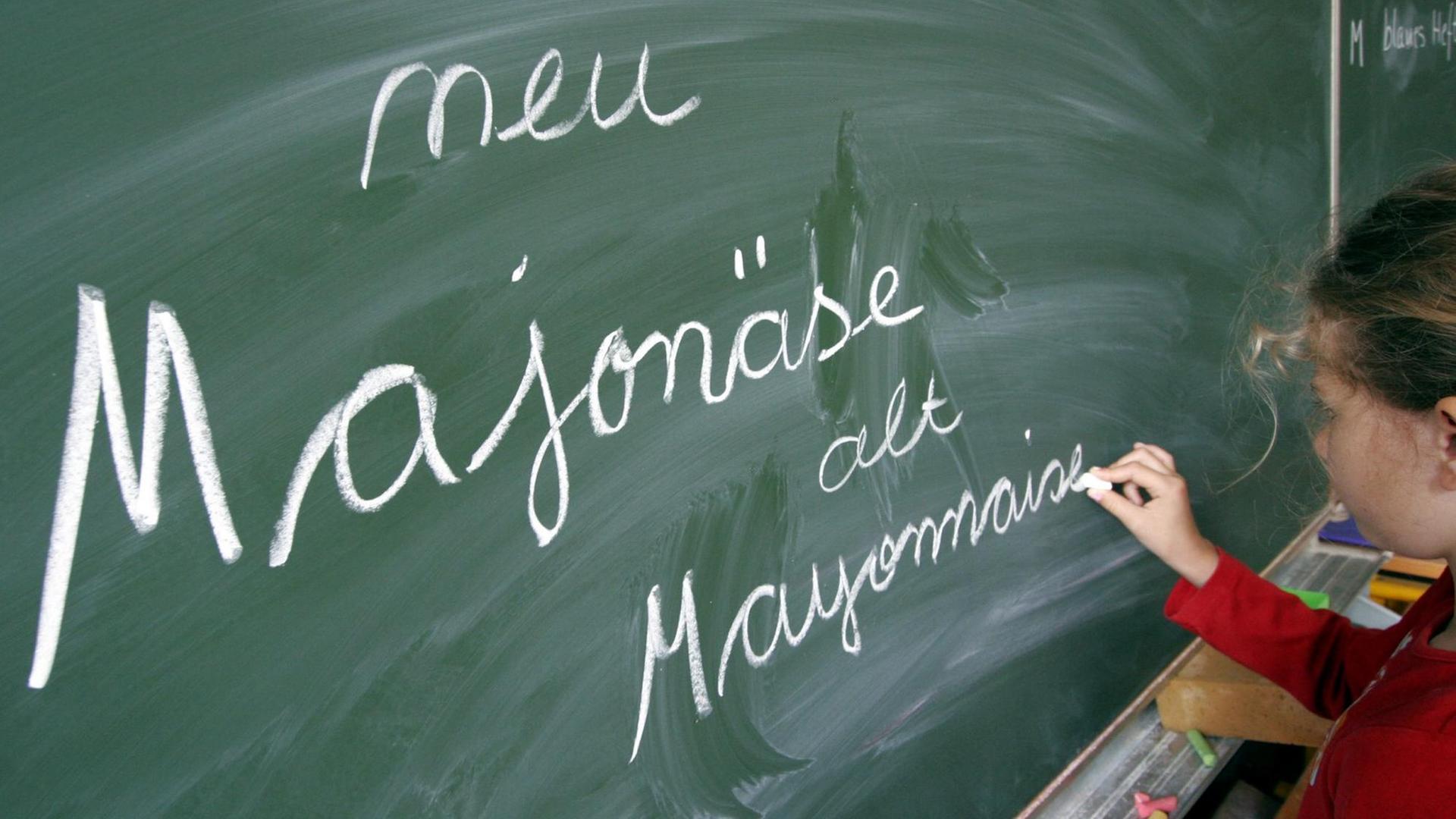 Eine Schülerin einer Frankfurter Grundschule schreibt die neue und alte Schreibweisen für das Wort "Majonäse" an eine Tafel (Foto vom 21.07.2005). Die unstrittigen Teile der Rechtschreibreform werden von 14 der 16 Bundesländer wie geplant am 1. August 2005 in Schulen und Behörden verbindlich eingeführt. Damit sind Bayern und Nordrhein-Westfalen die einzigen Bundesländer, die die Verbindlichkeit der 1998 eingeführten Reform verschieben und an der bisherigen Übergangsregelung festhalten. Foto: Frank Rumpenhorst +++(c) dpa - Report+++ | Verwendung weltweit Eine Schülerin einer Frankfurter Grundschule schreibt die neue und alte Schreibweisen für das Wort "Majonäse" an eine Tafel (Foto vom 21.07.2005). Die unstrittigen Teile der Rechtschreibreform werden von 14 der 16 Bundesländer wie geplant am 1. August 2005 in Schulen und Behörden verbindlich eingeführt. Damit sind Bayern und Nordrhein-Westfalen die einzigen Bundesländer, die die Verbindlichkeit der 1998 eingeführten Reform verschieben und an der bisherigen Übergangsregelung festhalten. Foto: Frank Rumpenhorst +++(c) dpa - Report+++ | Verwendung weltweit