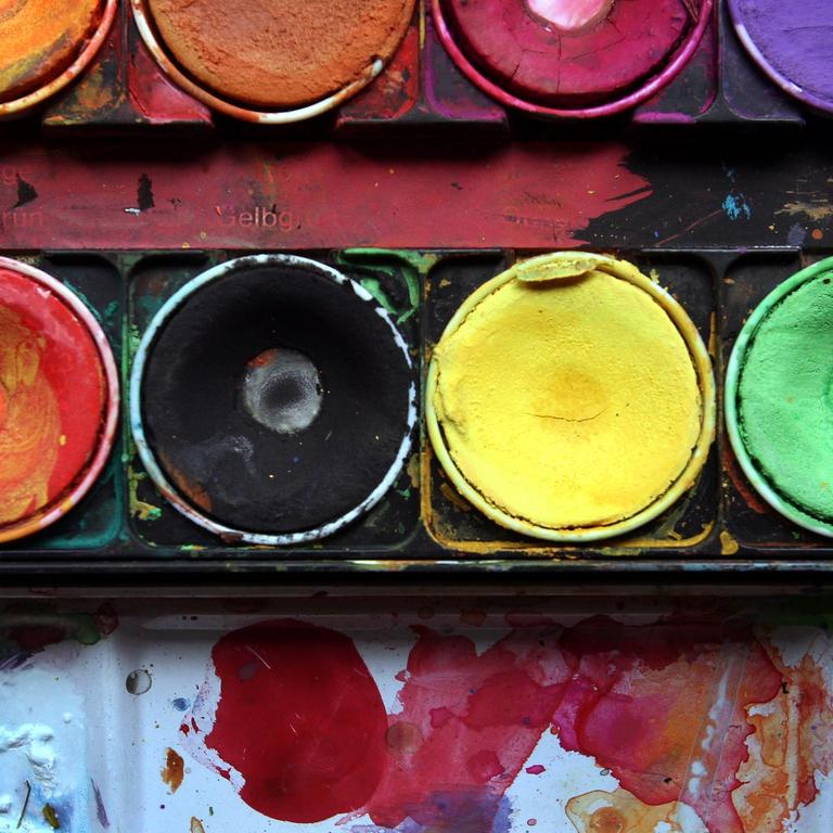 Die Farben Schwarz und Gelb liegen in einem Malkasten zusammen zwischen den Farben Rot und Grün 