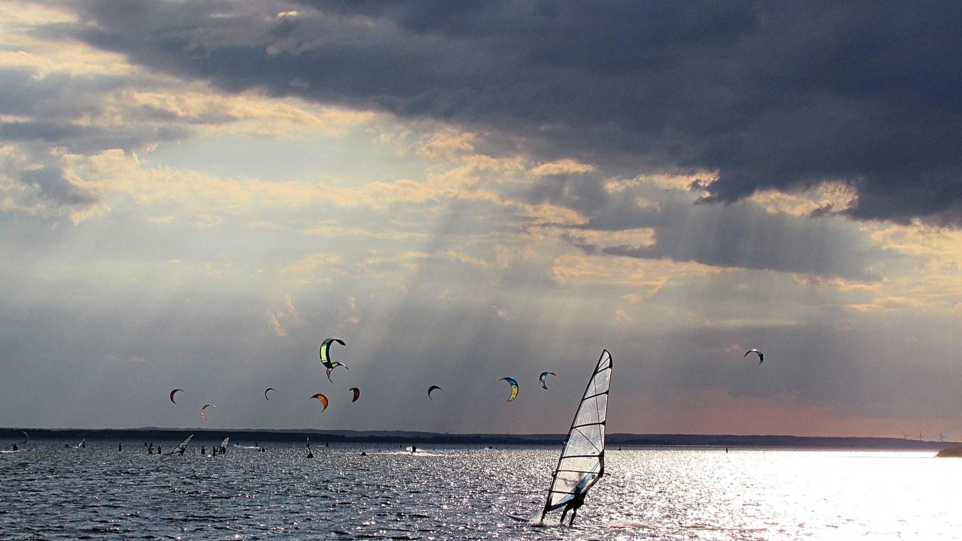Mehrere Kitesurfer auf dem Meer, bei dramatischem Sonnenlicht. Mehrere Kitesurfer auf dem Meer, bei dramatischem Sonnenlicht.