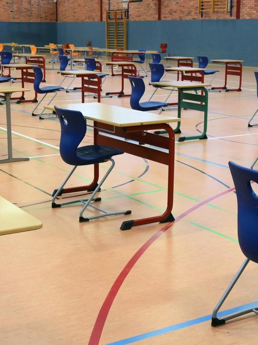 Mit großen Abständen stehen Tische und Stühle in der Turnhalle vom Montessori-Schulzentrum in Leipzig. In der Turnhalle sollen die Abiturprüfungen unter größten hygienischen Bedingungen geschrieben werden.