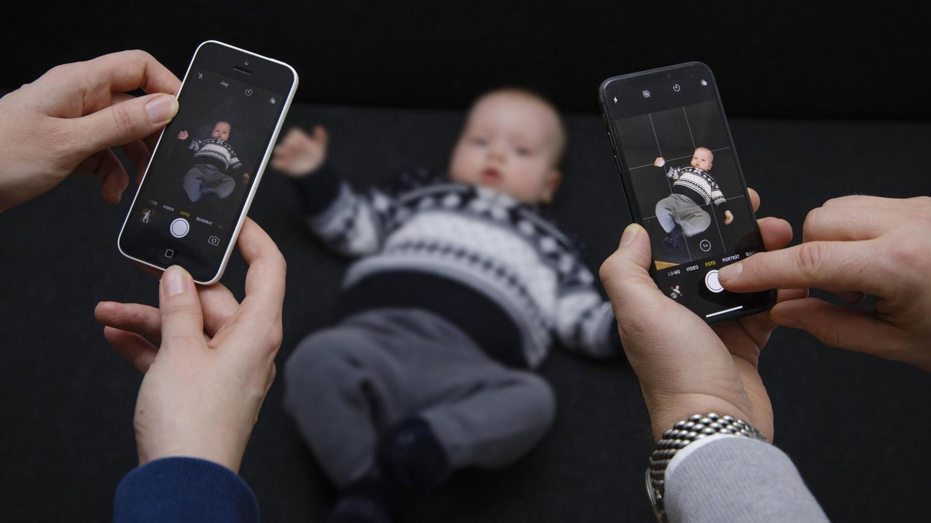 Ein Baby wird mit zwei Smartphones fotografiert