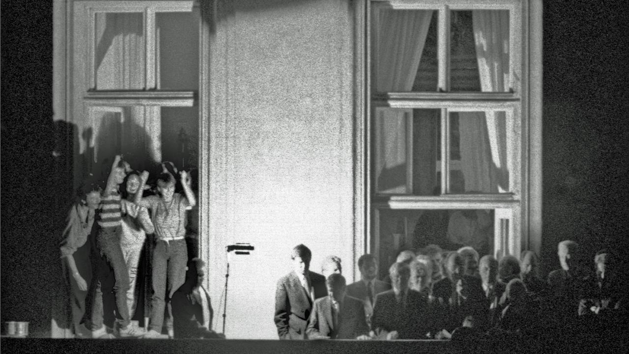 Bundesaußenminister Hans-Dietrich Genscher (Mitte vor dem Fensterkreuz rechts) verkündet am 30.09.1989 kurz vor 19 Uhr auf dem Balkon der Deutschen Botschaft in Prag: "Wir sind heute zu Ihnen gekommen, um Ihnen mitzuteilen, dass heute Ihre Ausreise....". Der weitere Wortlaut der Ankündigung der beschlossenen Ausreise der DDR-Flüchtlinge, die im Hof der Botschaft campierten, ging in tosendem Jubel unter.