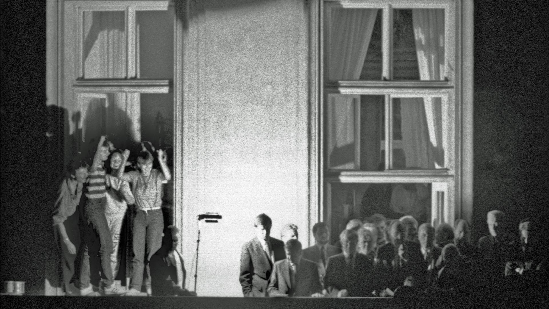Bundesaußenminister Hans-Dietrich Genscher (Mitte vor dem Fensterkreuz rechts) verkündet am 30.09.1989 kurz vor 19 Uhr auf dem Balkon der Deutschen Botschaft in Prag: "Wir sind heute zu Ihnen gekommen, um Ihnen mitzuteilen, dass heute Ihre Ausreise....". Der weitere Wortlaut der Ankündigung der bechlossenen Ausreise der DDR-Flüchtlinge, die im Hof der Botschaft campierten, ging in tosendem Jubel unter.