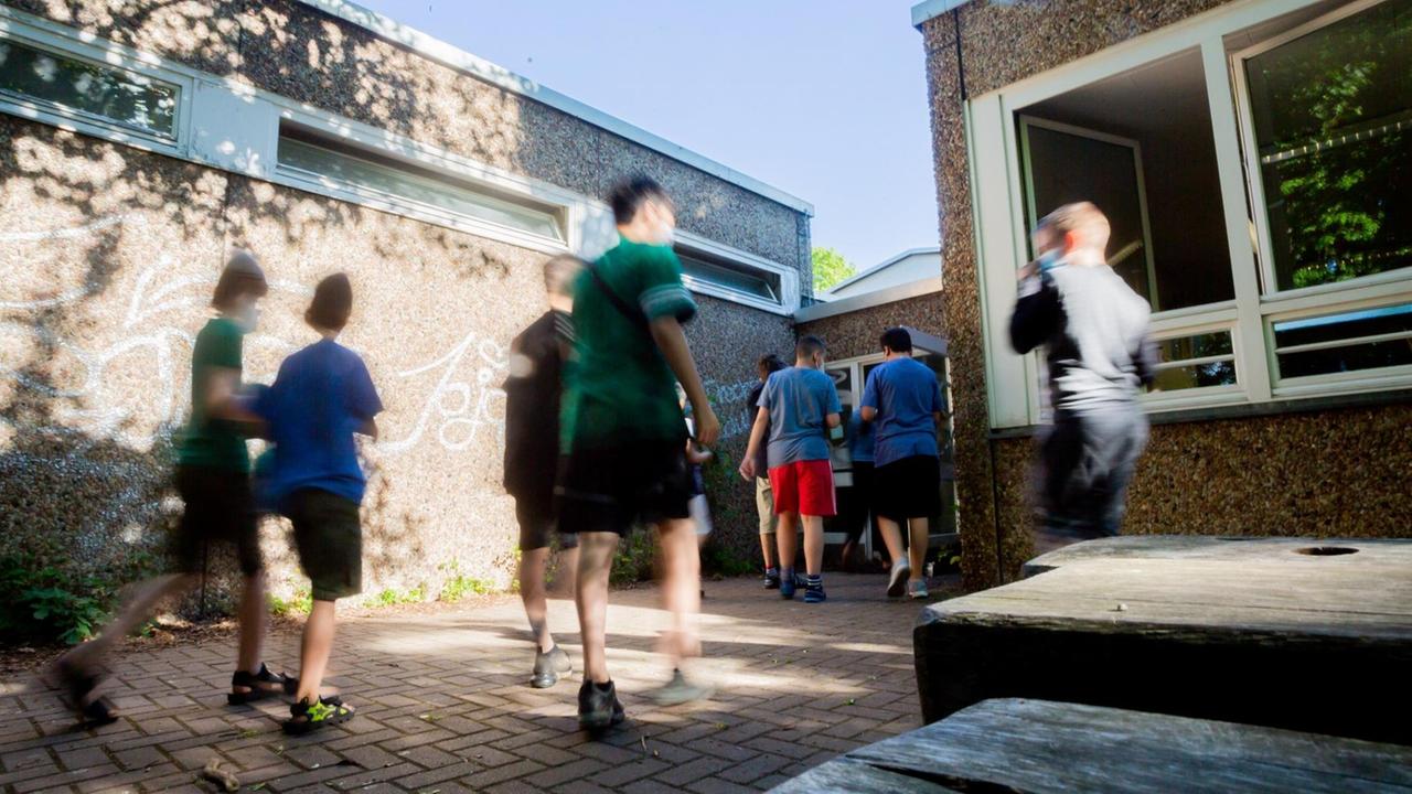 Schüler einer gemischten Klasse der Stufen 4-6 gehen nach dem auf dem Schulhof erfolgten Schnelltest wieder ins Klassenzimmer der Fritz-Karsen-Schule im Berliner Ortsteil Britz. (Bewegungsunschärfe durch lange Belichtungszeit) Für die letzten zwei Wochen vor den Sommerferien gibt es in der Hauptstadt noch einmal Präsenzunterricht mit allen Schülerinnen und Schülern. Schüler einer gemischten Klasse der Stufen 4-6 gehen nach dem auf dem Schulhof erfolgten Schnelltest wieder ins Klassenzimmer der Fritz-Karsen-Schule im Berliner Ortsteil Britz. (Bewegungsunschärfe durch lange Belichtungszeit) Für die letzten zwei Wochen vor den Sommerferien gibt es in der Hauptstadt noch einmal Präsenzunterricht mit allen Schülerinnen und Schülern.