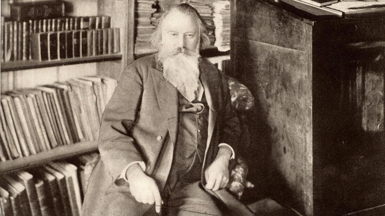 Der Komponist Johannes Brahms (1833-1897) sitzt auf einer zeitgenössischen Schwarz-weiss-Fotografie in seiner Bibliothek. Der Komponist Johannes Brahms (1833-1897) sitzt auf einer zeitgenössischen Schwarz-weiss-Fotografie in seiner Bibliothek.