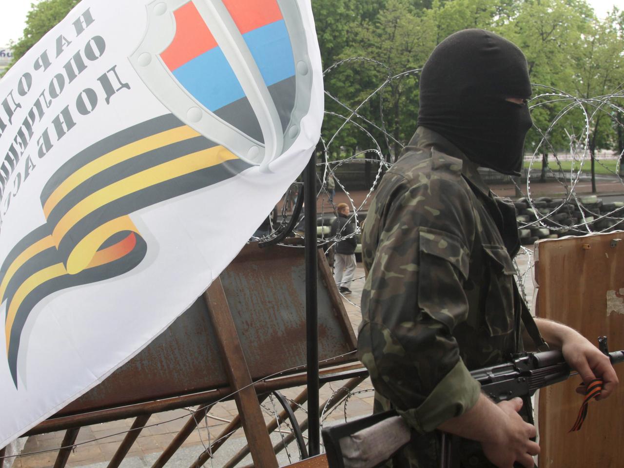 Bewaffneter in Lugansk mit Fahne Bewaffneter in Lugansk mit Fahne