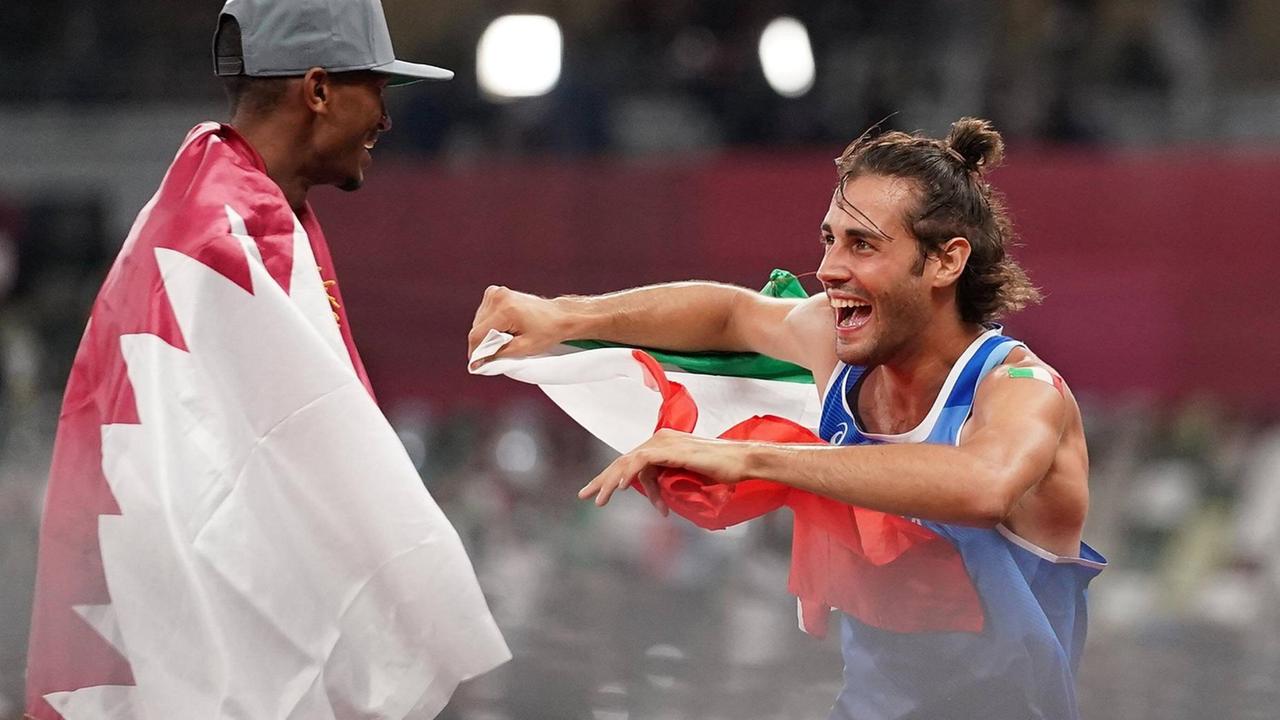Die Hoch-Springer Mutaz Essa Barshim und Gianmarco Tamberi tragen ihre Landes-Flaggen und freuen sich. Die Hoch-Springer Mutaz Essa Barshim und Gianmarco Tamberi tragen ihre Landes-Flaggen und freuen sich.