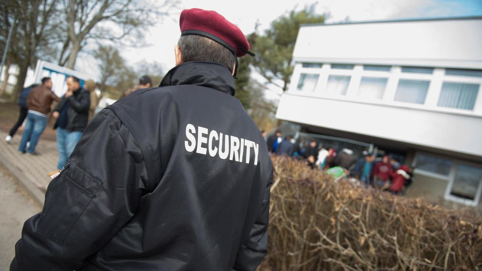 Eine Sicherheitskraft vor einem Flüchtlingsheim Eine Sicherheitskraft vor einem Flüchtlingsheim