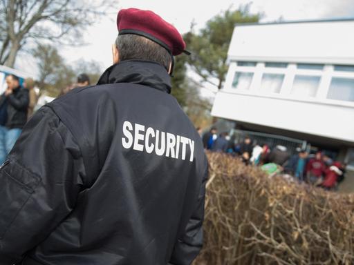 Eine Sicherheitskraft vor einem Flüchtlingsheim