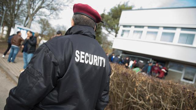 Eine Sicherheitskraft vor einem Flüchtlingsheim