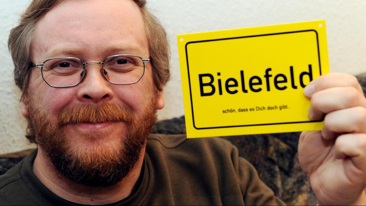 Achim Held, Erfinder der Bielefeld-Verschwörung zeigt am 05. Mai 2013 in Kiel ein Schild mit der Aufschrift "Bielefeld - schön dass es dich doch gibt". Achim Held, Erfinder der Bielefeld-Verschwörung zeigt am 05. Mai 2013 in Kiel ein Schild mit der Aufschrift "Bielefeld - schön dass es dich doch gibt".