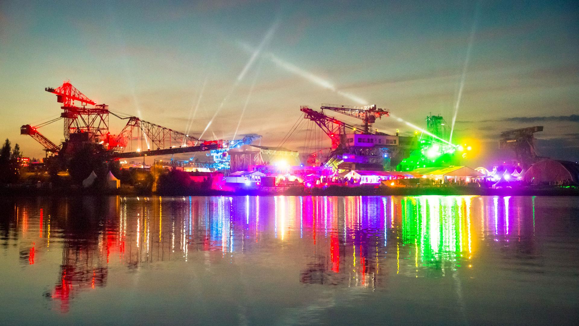 Kräne werden beim Melt!-Festival in buntes Licht getaucht. Kräne werden beim Melt!-Festival in buntes Licht getaucht.
