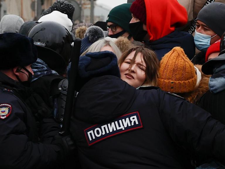 Polizisten drängen am 23. Januar 2021 in Moskau mit dem Schlagstock in der Hand protestierende Menschen zurück, die die Freilassung des Oppositionsführers Alexej Nawalny fordern.