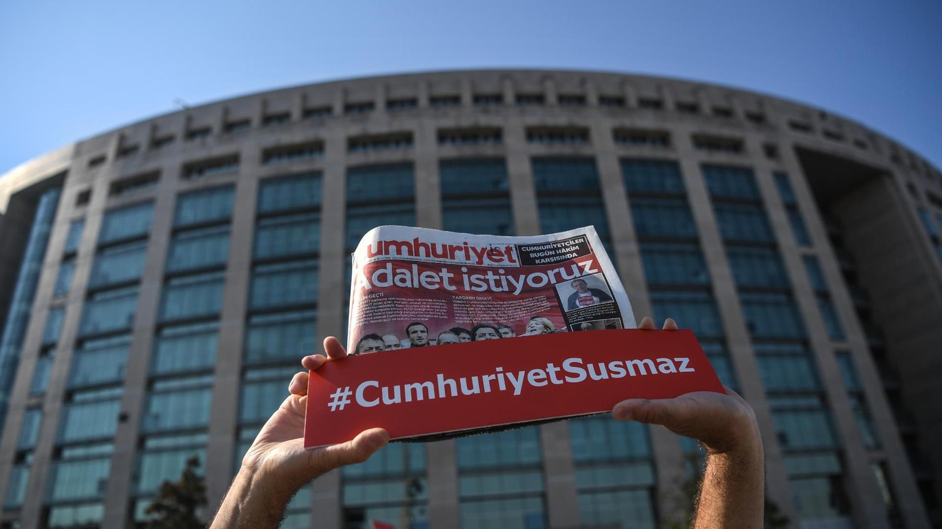 Vor dem Justizpalast in Istanbul hält eine Person einen Banner mit der Aufschrift #CumhuriyetSusmaz in die Luft Vor dem Justizpalast in Istanbul hält eine Person einen Banner mit der Aufschrift #CumhuriyetSusmaz in die Luft