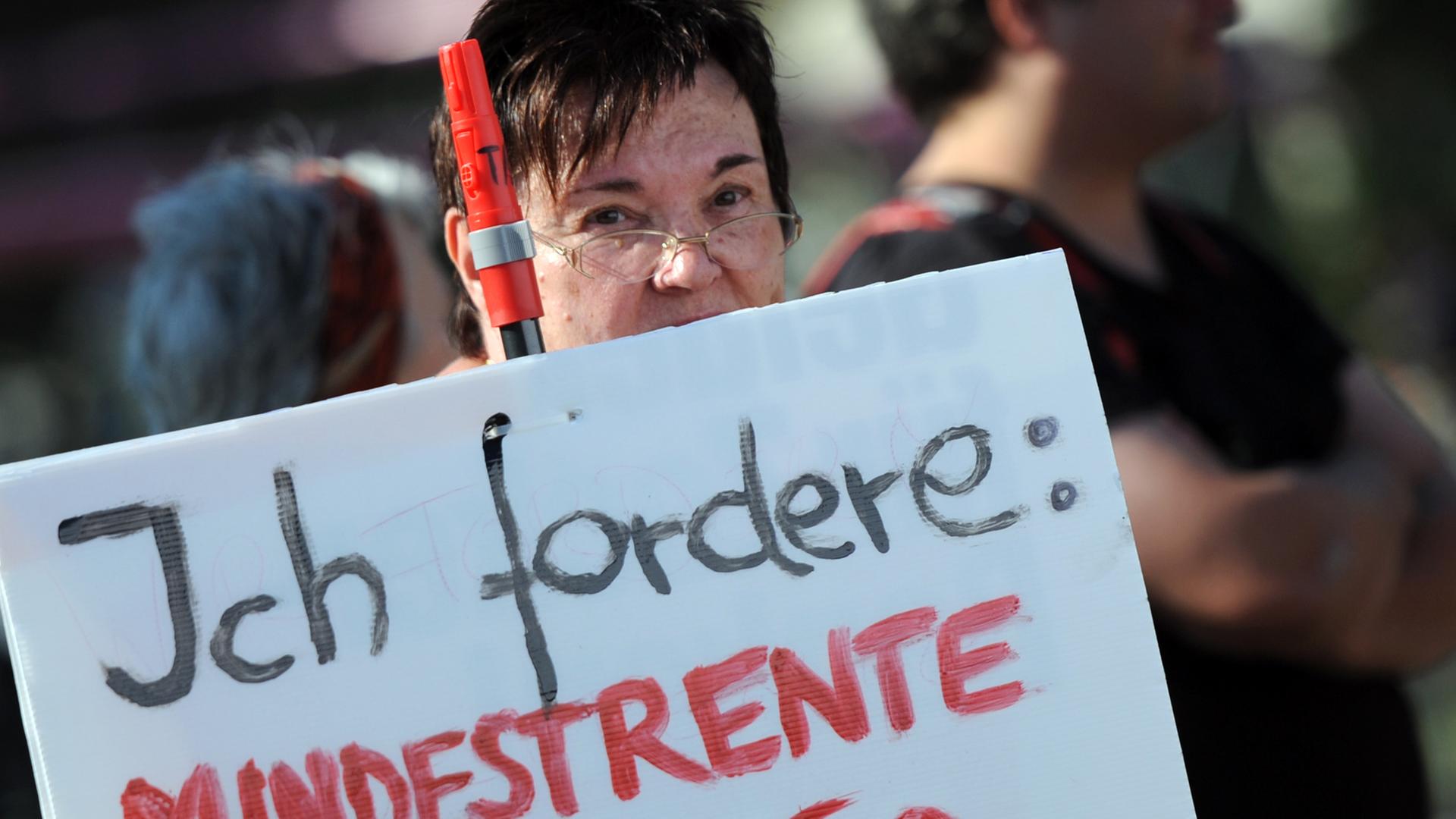 Eine Demonstrantin zeigt am 04.10.2014 in Berlin ein Schild mit der Aufschrift "Ich fordere: Mindestrente Euro 1250,-". Eine Demonstrantin zeigt am 04.10.2014 in Berlin ein Schild mit der Aufschrift "Ich fordere: Mindestrente Euro 1250,-".