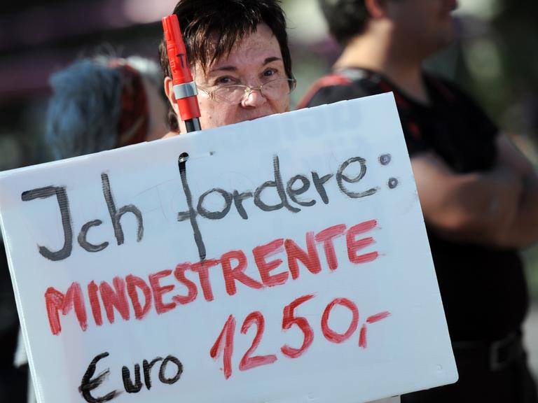 Eine Demonstrantin zeigt am 04.10.2014 in Berlin ein Schild mit der Aufschrift "Ich fordere: Mindestrente Euro 1250,-".