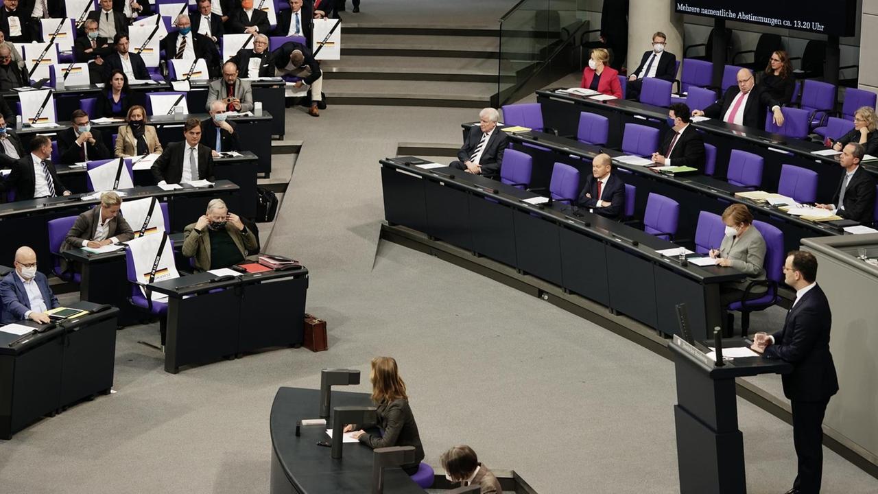 18.11.2020, Berlin: Jens Spahn (CDU), Bundesminister für Gesundheit, sprichtt in der Debatte vor der Verabschiedung der Änderung des Infektionsschutzgesetzes, dem Gesetzes zum Schutz der Bevölkerung bei einer epidemischen Lage von nationaler Tragweite. Im Hintergrund haben Abgeordnete der AfD Plakate mit der Aufschrift Grundgesetz und dem heutigen Datum. In dem Gesetz sollen weitreichende Maßnahmen beschlossen werden die bei einer Lage wie der Corona Pandemie Regierungshandeln ermöglichen . Foto: Michael Kappeler/dpa | Verwendung weltweit 18.11.2020, Berlin: Jens Spahn (CDU), Bundesminister für Gesundheit, sprichtt in der Debatte vor der Verabschiedung der Änderung des Infektionsschutzgesetzes, dem Gesetzes zum Schutz der Bevölkerung bei einer epidemischen Lage von nationaler Tragweite. Im Hintergrund haben Abgeordnete der AfD Plakate mit der Aufschrift Grundgesetz und dem heutigen Datum. In dem Gesetz sollen weitreichende Maßnahmen beschlossen werden die bei einer Lage wie der Corona Pandemie Regierungshandeln ermöglichen . Foto: Michael Kappeler/dpa | Verwendung weltweit
