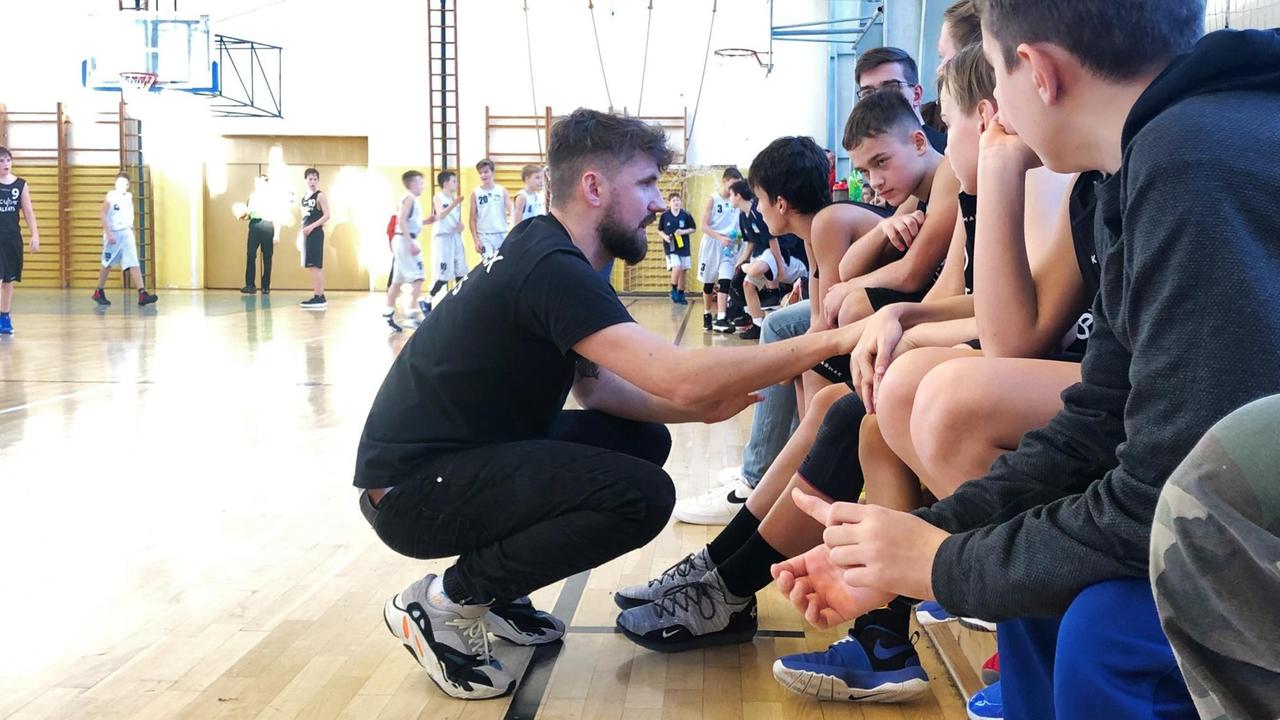 Trainer Johannes Ködel kniet vor seiner Mannschaft, die auf der Bank sitzt. Trainer Johannes Ködel kniet vor seiner Mannschaft, die auf der Bank sitzt.