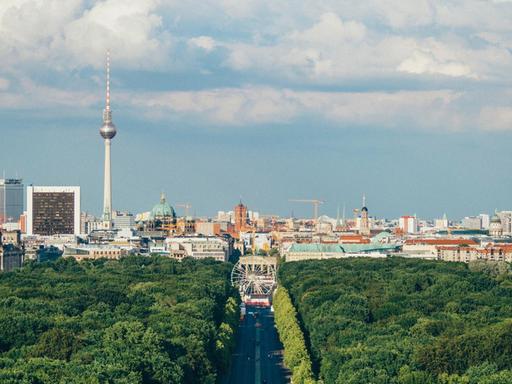 Eine Totale zeigt den Blick über den Tiergarten und die Straße des 17. Juni in Richtung Berliner Zentrum mit dem Fernsehturm.