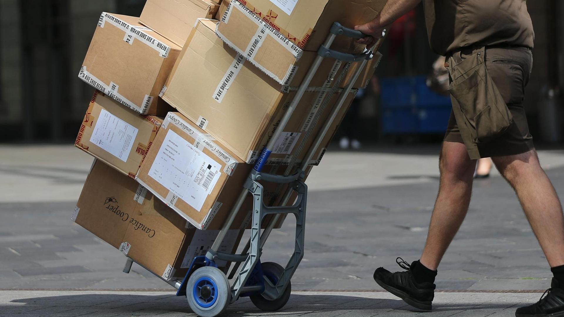 Ein Paketbote liefert Pakete aus. Ein Paketbote liefert Pakete aus.