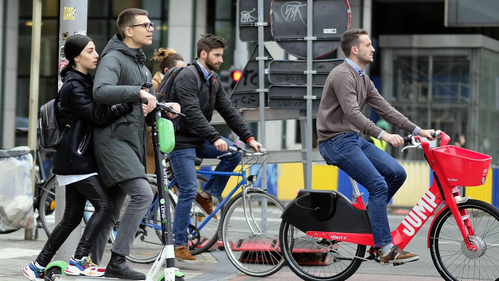 In Brüssel fährt ein Mann auf einem E-Tretroller über eine Straße. In Brüssel fährt ein Mann auf einem E-Tretroller über eine Straße.