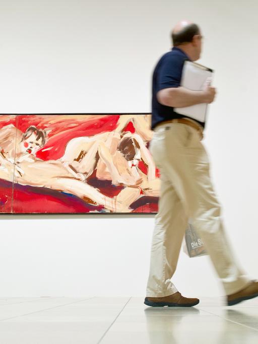 Ein Mann blickt am 21.07.2015 in der Kunstausstellung "Die 80er. Figurative Malerei in der BRD" im Städel Museum in Frankfurt am Main auf die Kunstwerke "Babylon" (l) und "Sumokämpfer blau" von dem Berliner Maler Salomé.